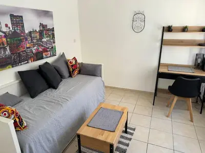 a living room with a couch and a desk at Studio lumineux in Nice