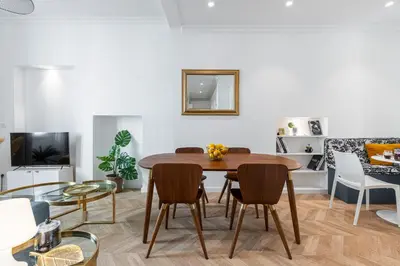 a living room with a wooden table and chairs at 37 MASSENA LOT 2 - Superbe 3 pieces - Zone Pietonne - A-C in Nice