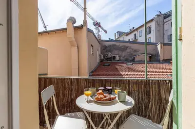 a table with a bowl of food on a balcony at 37 MASSENA LOT 2 - Superbe 3 pieces - Zone Pietonne - A-C in Nice