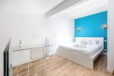 a bedroom with a white bed and a blue wall at 5 FODERE - Magnifique Duplex - Port de Nice - Dernier etage in Nice