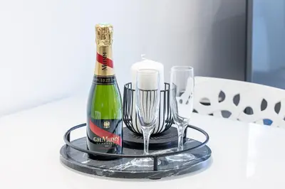 a bottle of champagne and two glasses on a table at 5 FODERE - Magnifique Duplex - Port de Nice - Dernier etage in Nice