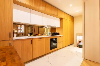 a kitchen with wooden cabinets and a sink at COSY VOLTI AP4434 By Riviera Holiday Homes in Villefranche-sur-Mer