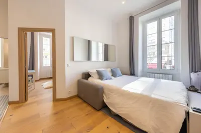 a bedroom with a large bed and a large window at Le Carré d'Or - à 2 min à pied du centre-ville in Nice