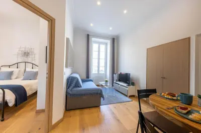 a bedroom with a bed and a couch and a television at Le Carré d'Or - à 2 min à pied du centre-ville in Nice