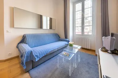 a living room with a blue couch and a table at Le Carré d'Or - à 2 min à pied du centre-ville in Nice