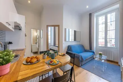 a living room with a table and a blue chair at Le Carré d'Or - à 2 min à pied du centre-ville in Nice