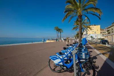 a row of blue bikes parked next to the beach at Apartment La Fenice - Happy Rentals in Nice