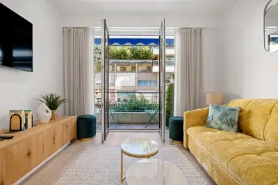 a living room with a yellow couch and a large window at Massenet Dream,Nice in Nice