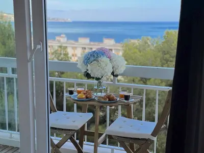 a table with a vase of flowers on a balcony at ⁂ Luxueux 3 pièces 300m de la plage clim sauna in Nice