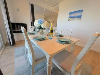 a white dining room table with chairs and a table at ⁂ Luxueux 3 pièces 300m de la plage clim sauna in Nice
