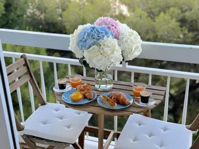 a table with breakfast foods and a vase of flowers at ⁂ Luxueux 3 pièces 300m de la plage clim sauna in Nice