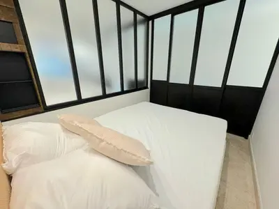 a white bed with a pillow in a room with windows at ⁂ Magnifique 3P cœur du Vieux Nice in Nice