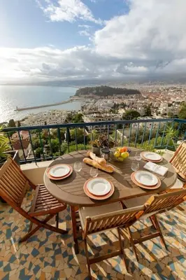 a table with plates of food on top of a balcony at Magnifique appartement vue mer Mont Borron in Nice