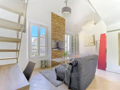 a living room with a couch and a staircase at Cosy duplex, hyper centre, wifi,air conditionner in Nice