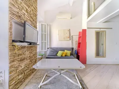 a living room with a couch and a tv at Cosy duplex, hyper centre, wifi,air conditionner in Nice