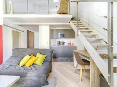 a bedroom with a bed with yellow pillows and a staircase at Cosy duplex, hyper centre, wifi,air conditionner in Nice