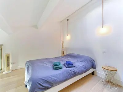 a bedroom with a bed with blue shoes on it at Cosy duplex, hyper centre, wifi,air conditionner in Nice