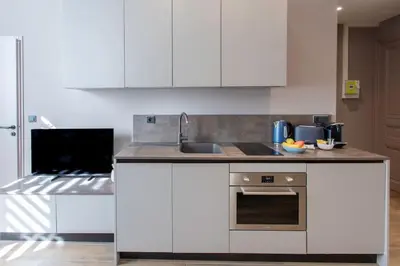 a kitchen with white cabinets and a sink and a stove at #61 1 BDR Rossini Centrale Balcony AC in Nice