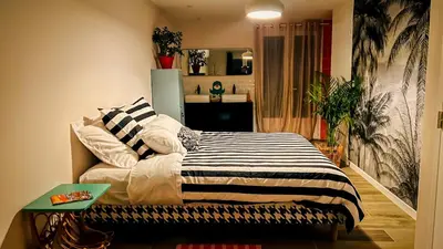 a bedroom with a bed with a striped blanket on it at Maison LeFleur in Falicon