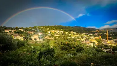 a rainbow over a town with houses on a hill at Maison LeFleur in Falicon
