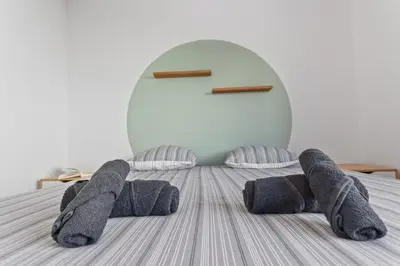 a room with a bed with gray socks on it at Le Cosy - Spacious - AC - WIFI - Hippodrome - Racetracks - Hypercentre in Cagnes-sur-Mer