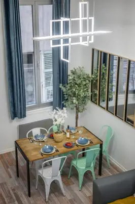a dining room with a table and chairs and a chandelier at Spacieux Loft & Central- Vieux Nice in Nice
