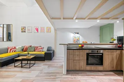 a kitchen and a living room with a couch at Spacieux Loft & Central- Vieux Nice in Nice
