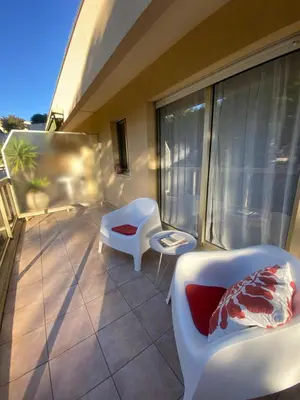 a balcony with a couch and chairs on a building at Lovely studio apartment in Nice