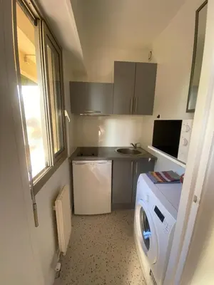a small kitchen with a washing machine in a room at Lovely studio apartment in Nice