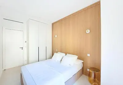 a bedroom with a white bed and a wooden wall at Nestor&Jeeves - PALMIERS TERRASSE - Central - Terrace in Nice