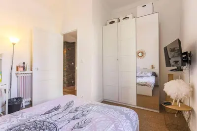 a bedroom with white cabinets and a bed and a television at Appartement 2 chambres à 15 mn de la mer in Nice