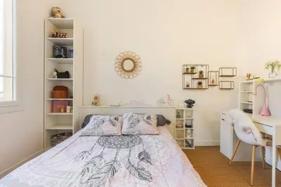 a white bedroom with a bed and a desk at Appartement 2 chambres à 15 mn de la mer in Nice