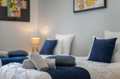 a room with two beds with blue pillows at La Galerie 58 - Luxe & Design en centre ville in Nice