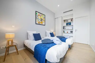 two beds in a bedroom with blue and white at La Galerie 58 - Luxe & Design en centre ville in Nice