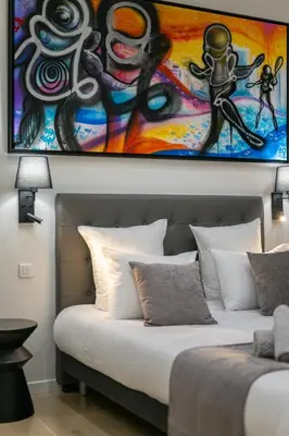 a bedroom with a bed with a painting on the wall at La Galerie 58 - Luxe & Design en centre ville in Nice