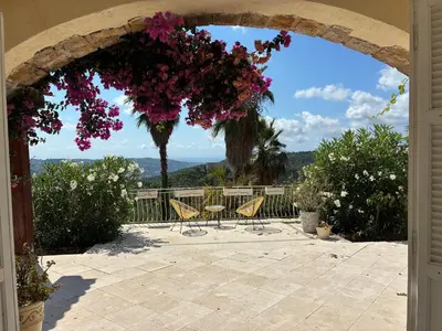 an archway with a table and chairs and flowers at Villa Gloria Nouvel Hôte in Saint-Jeannet