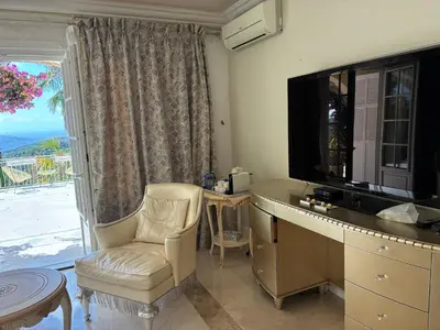 a room with a tv and a chair and a window at Villa Gloria Nouvel Hôte in Saint-Jeannet