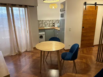 a kitchen with a table and two blue chairs at Elégant studio de 25m2 in Saint-Laurent-du-Var