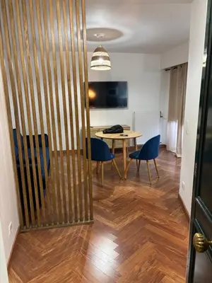 a dining room with a table and blue chairs at Elégant studio de 25m2 in Saint-Laurent-du-Var