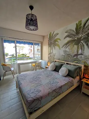 a bedroom with a bed and a large window at Studio vue mer in Cagnes-sur-Mer
