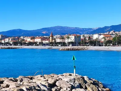a green sign on top of a rock in the water at Studio vue mer in Cagnes-sur-Mer