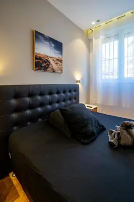 a bedroom with a large bed with a leather headboard at Cosy 2P Promenade des Anglais in Nice