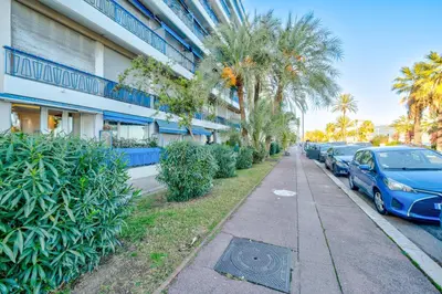 a street with cars parked in front of a building at Cosy 2P Promenade des Anglais in Nice