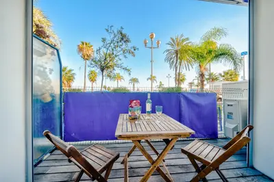 a wooden table and two chairs on a patio at Cosy 2P Promenade des Anglais in Nice