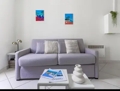 a living room with a purple couch and a table at Résidence le Paga in Nice