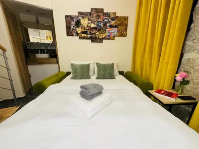 a large white bed in a room with a yellow curtain at Amber Apartment Nice - Central Highlights and Beach in Nice