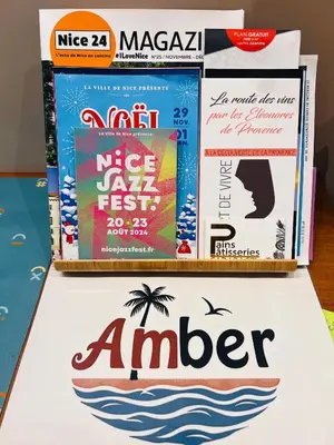 a pile of books sitting on top of a table at Amber Apartment Nice - Central Highlights and Beach in Nice