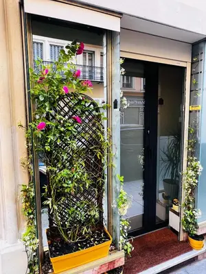 an open door with pink flowers on a building at Amber Apartment Nice - Central Highlights and Beach in Nice