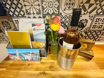 a bottle of wine in a bucket on a table at Amber Apartment Nice - Central Highlights and Beach in Nice