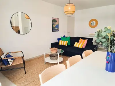 a living room with a black couch and a table at Magnifique Appartement - Parking privé - Nice in Nice